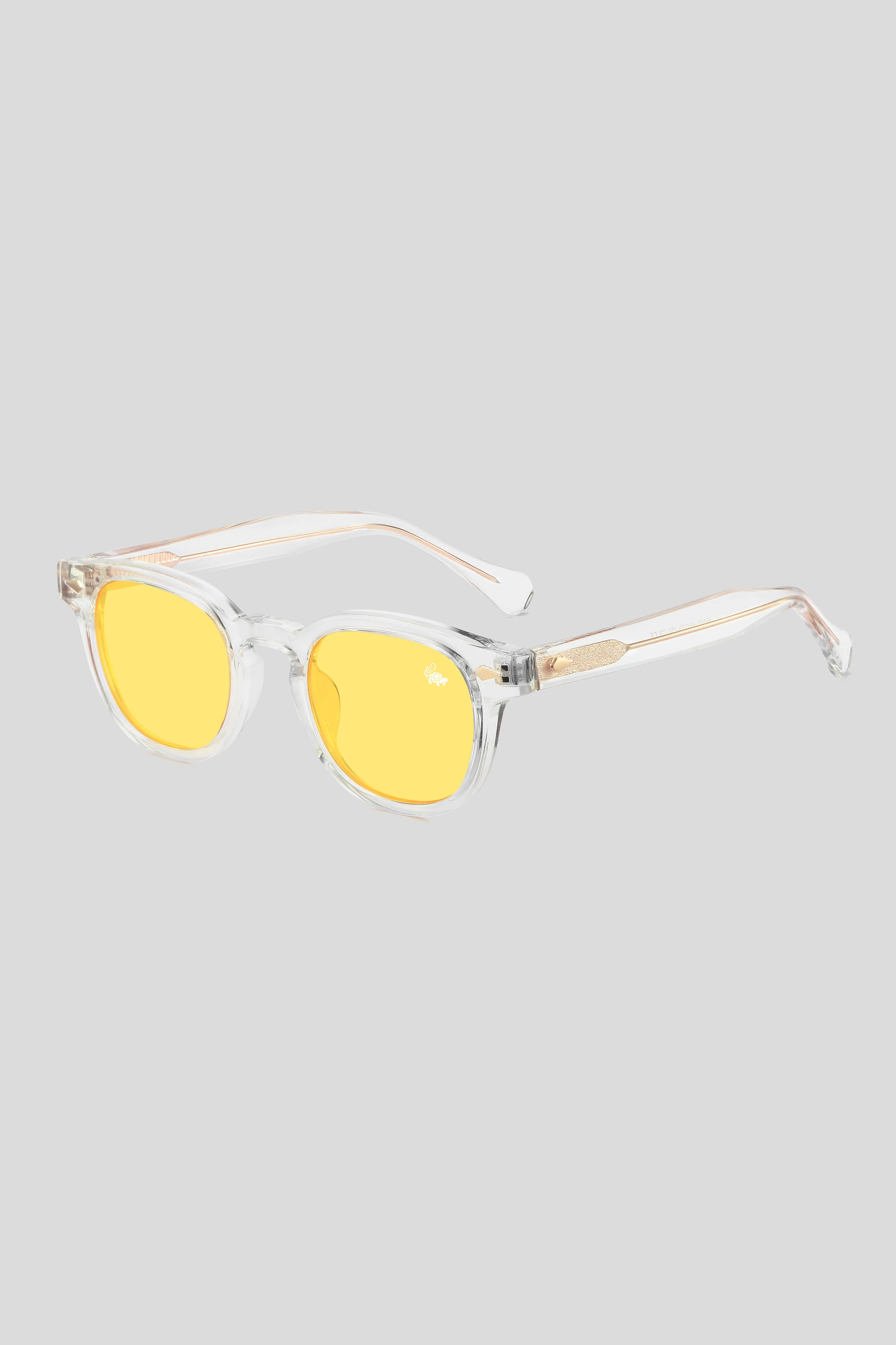 Sunglasses with yellow lenses and clear frame on a light gray background